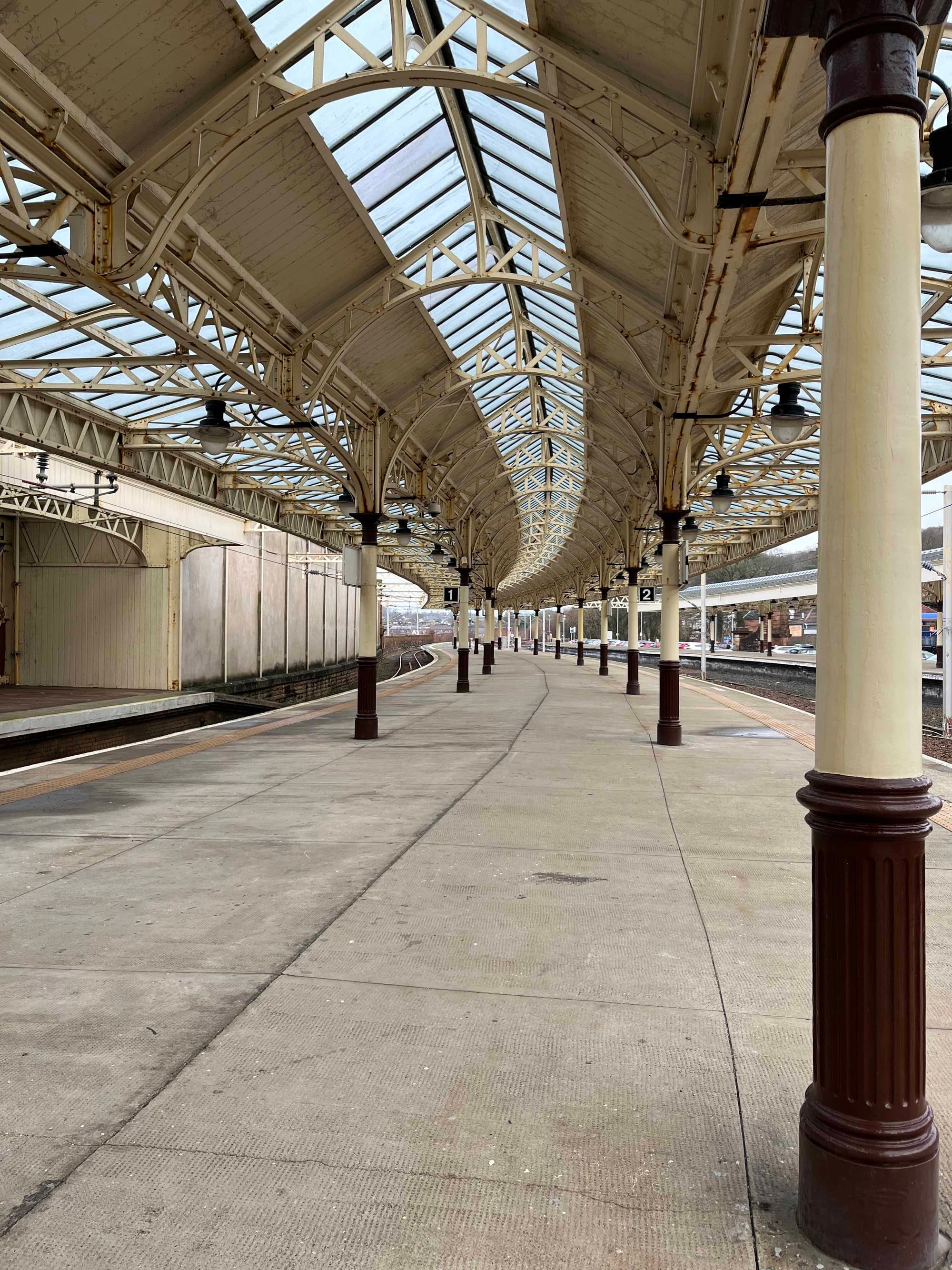 Curved canopy and pillars on a railway platform between tracks
