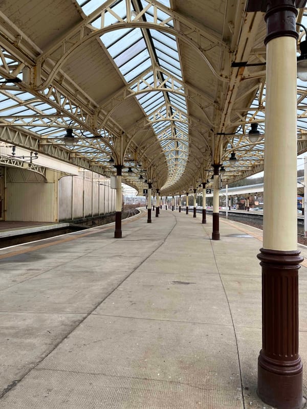 Curved canopy and pillars on a railway platform between tracks